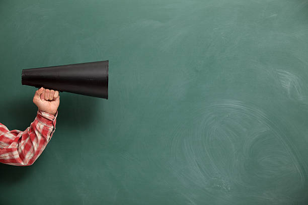 istock Old Fashioned Megaphone In Human Hand On Green Blank Blackboard 185097539