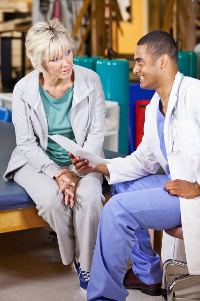 istock Mature woman talking with physical therapist 185097634