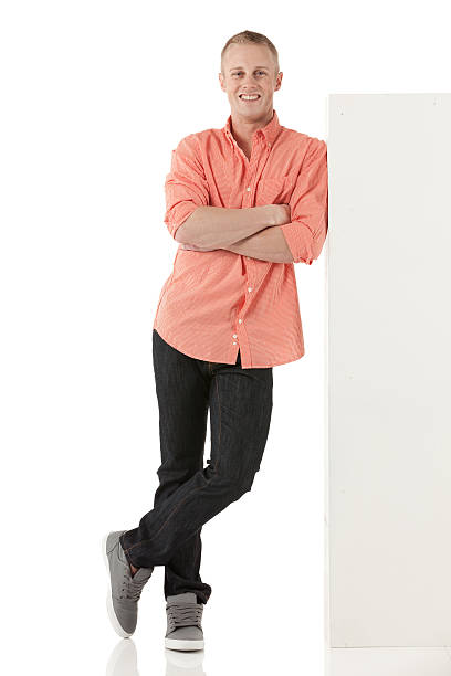Man standing with arms crossed leaning on a white ledge Man standing with arms crossed leaning on a white ledge leaning stock pictures, royalty-free photos & images