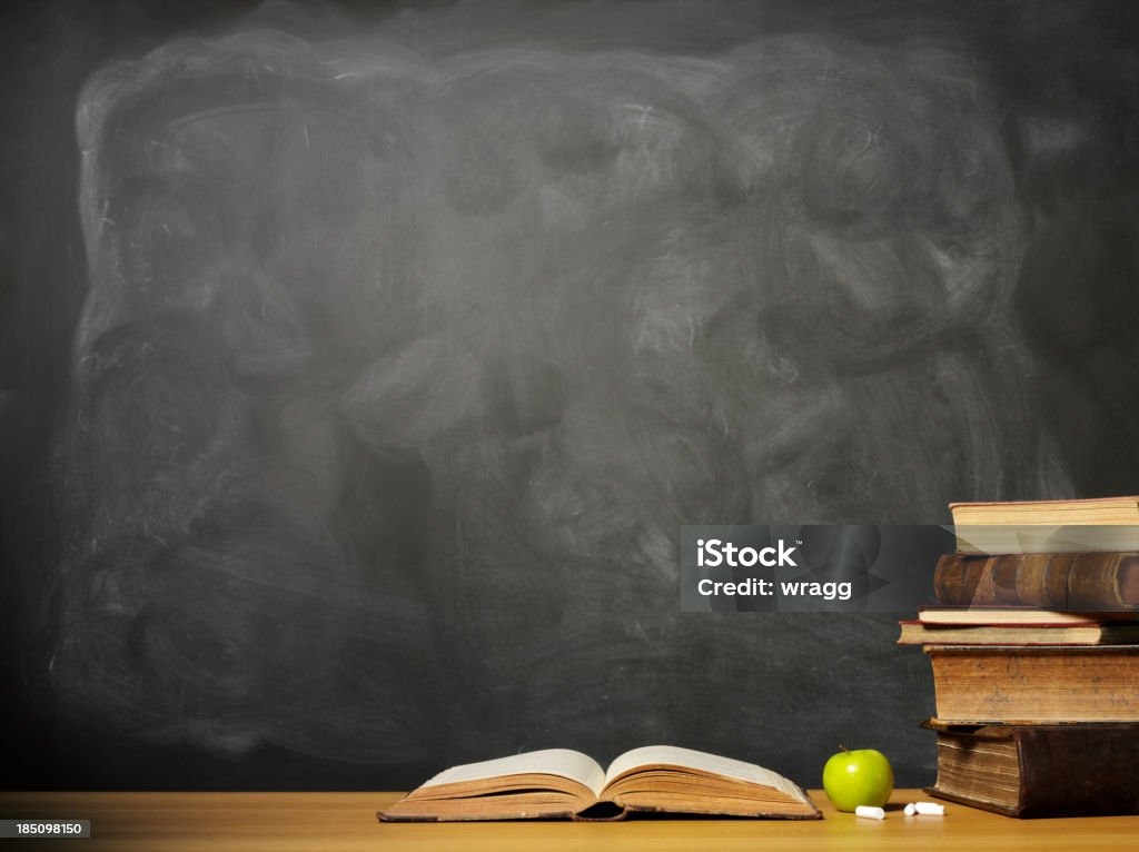 Livros e maçã em uma mesa em frente ao chalkboard - Foto de stock de Quadro-negro royalty-free