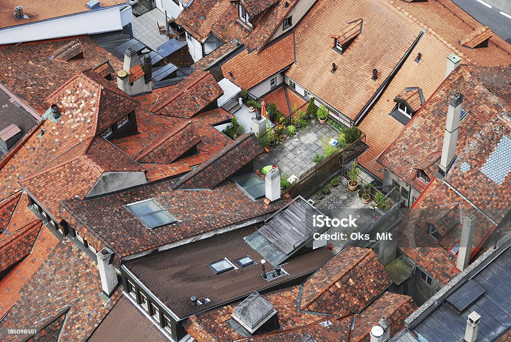 Rooftops of the old city with roof gardens. Red tiled roofs of townhouses tightly adjacent to each other. There are several roof gardens among them. The old city of Fribourg is photographed from above. Above Stock Photo