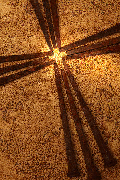 Religious: Cross of Old Square Rusty Nails on gold background stock photo