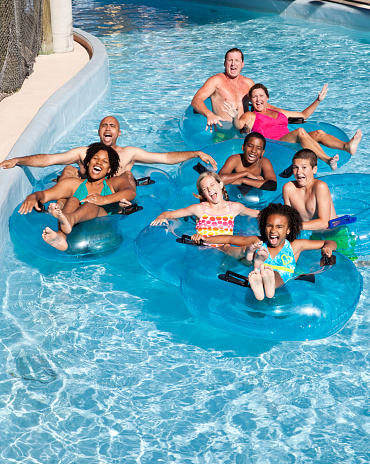 Two families floating down lazy river at water park.