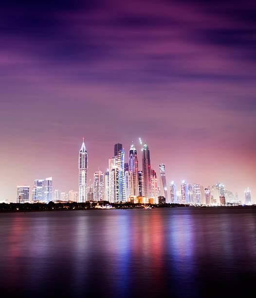 Illuminated Dubai Marina at Night United Arab Emirates The Dubai Marina at dusk, Untied Arab Emirates, view from the Palm Jumeirah. Blurred clouds due to the long exposure. dubai marina panorama stock pictures, royalty-free photos & images