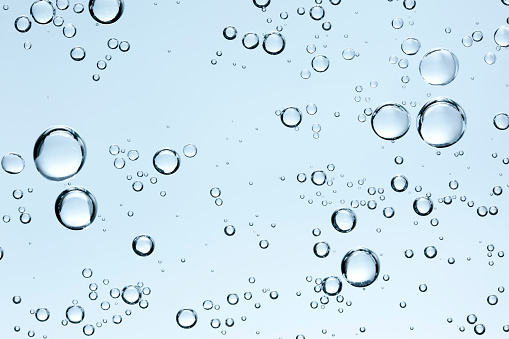 Burbujas en el agua clara frescos sobre fondo azul photo