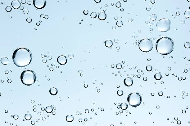 bulles dans l'eau claire sur fond bleu frais - goutte état liquide photos et images de collection