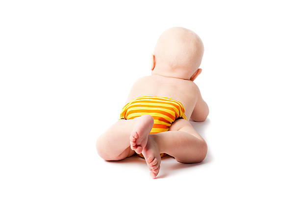 Blond baby lying on his stomach with cloth diaper stock photo