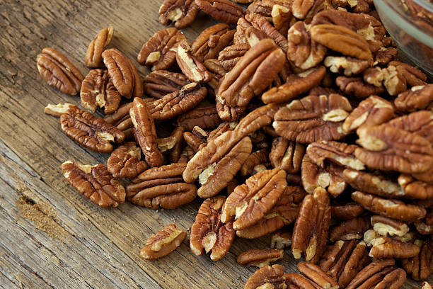 Pecan nuts on rustic wood table stock photo
