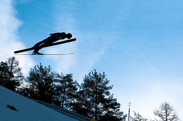 istock Ski jumper in mid-air against the blue sky 185100032
