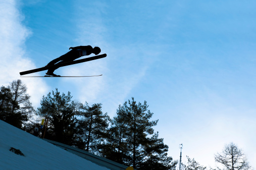 Ski jumper in mid-air against the blue sky