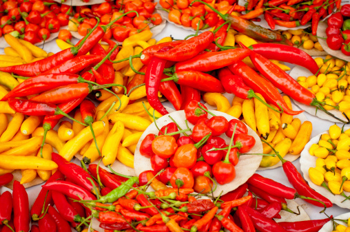 Asortment of Brazilian Hot peppers laid in a street market table in disarray.