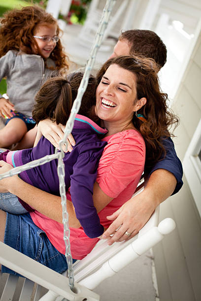 istock Happy Sisters Playing With Mom and Dad on Porch Swing 185100451