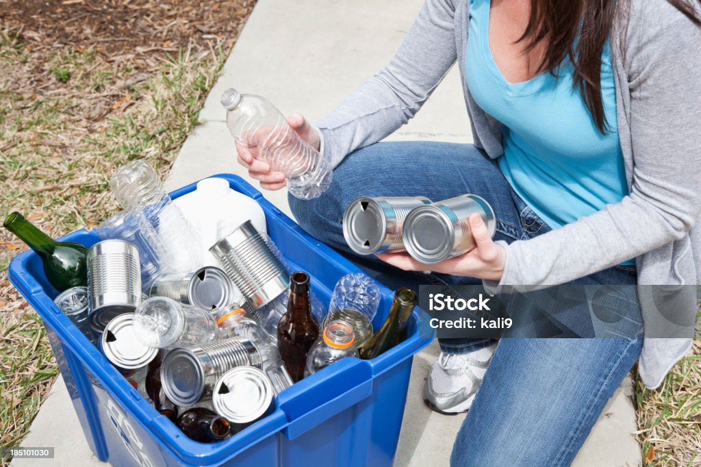 Kobieta wprowadzenie puszek i butelek w Pojemnik na segregowane odpady - Zbiór zdjęć royalty-free (Odpady)