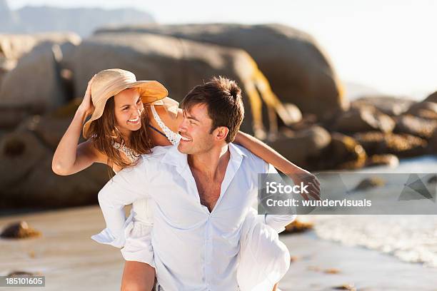 Loving Couple Piggybacking Together Stock Photo - Download Image Now - Couple - Relationship, Beach, Embracing