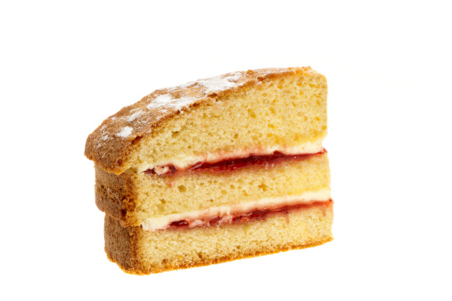 A slice of Victoria sponge cake - studio shot with a white background