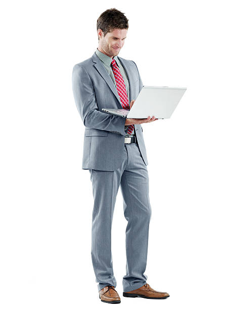 istock Handsome businessman standing smiling holding a laptop 185101965
