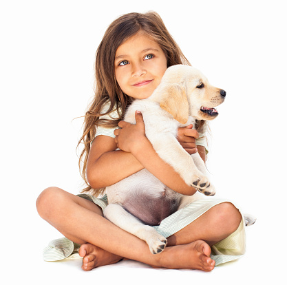 Cute little girl holding her pet affectionately, looking into copy space.