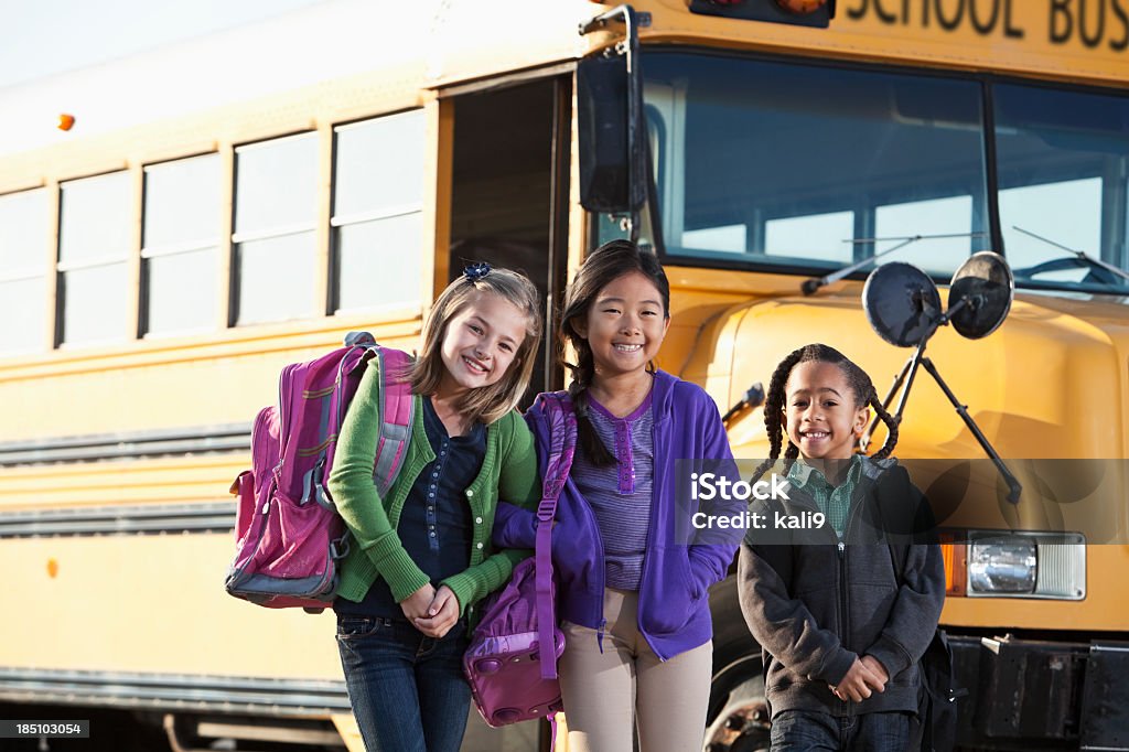 Crianças em pé do lado de fora do ônibus escolar - Foto de stock de Aluna royalty-free