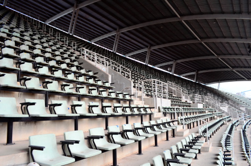 Football or soccer fans are cheering for their team at the stadium on the match