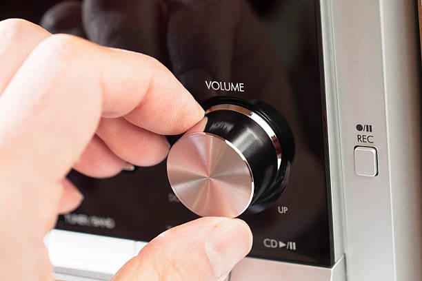 Turning the volume knob on a hi fi Man's hand turning the volume knob on a hi fi volume knob photos stock pictures, royalty-free photos & images