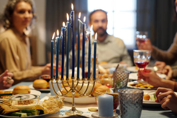 istock Burning candles on menorah candlestick standing on table served for dinner 1851049233