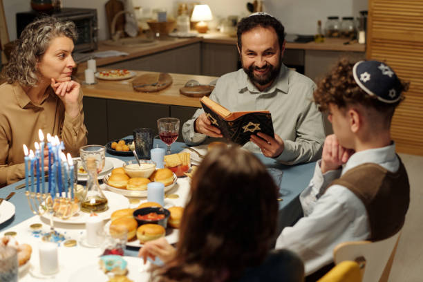 istock Happy bearded man with open Scripture sitting in front of his family 1851049781