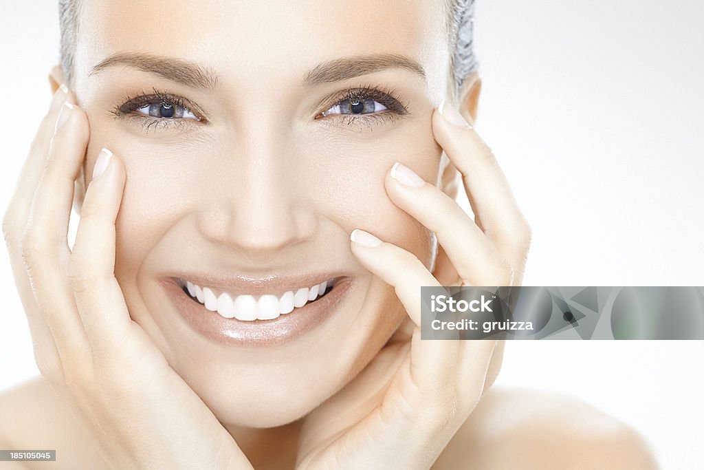 Donna sorridente con viso con le mani - Foto stock royalty-free di Donne