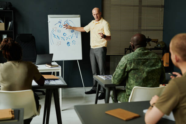 istock Confident mature teacher pointing at whiteboard with arrows and sketches 1851056778