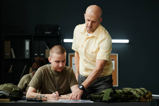 istock Confident mature coach of military training pointing at notes of student 1851057874