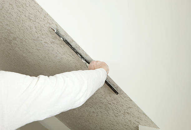 Worker Troweling Drywall Mud on a Ceiling for Knockdown Texture stock photo