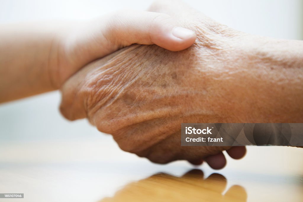 Personnes âgées Main tenant les mains de bébé - Photo de Aide familiale libre de droits