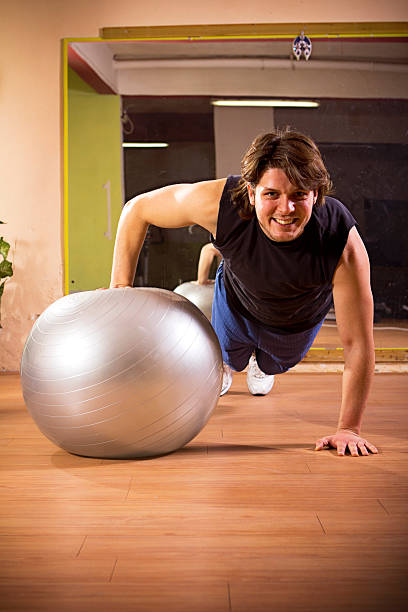 istock Athletic young man exercising on pilates ball 185107294