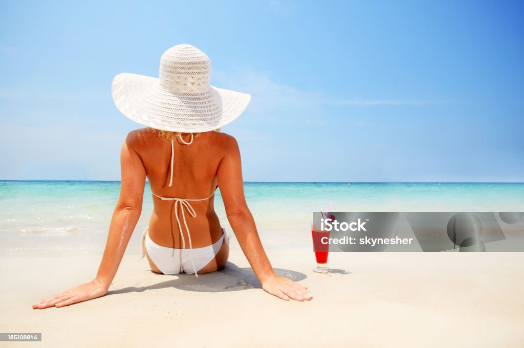 Attraktive Frau trägt einen Hut am Strand gegen Himmel. - Lizenzfrei Alkoholisches Getränk Stock-Foto