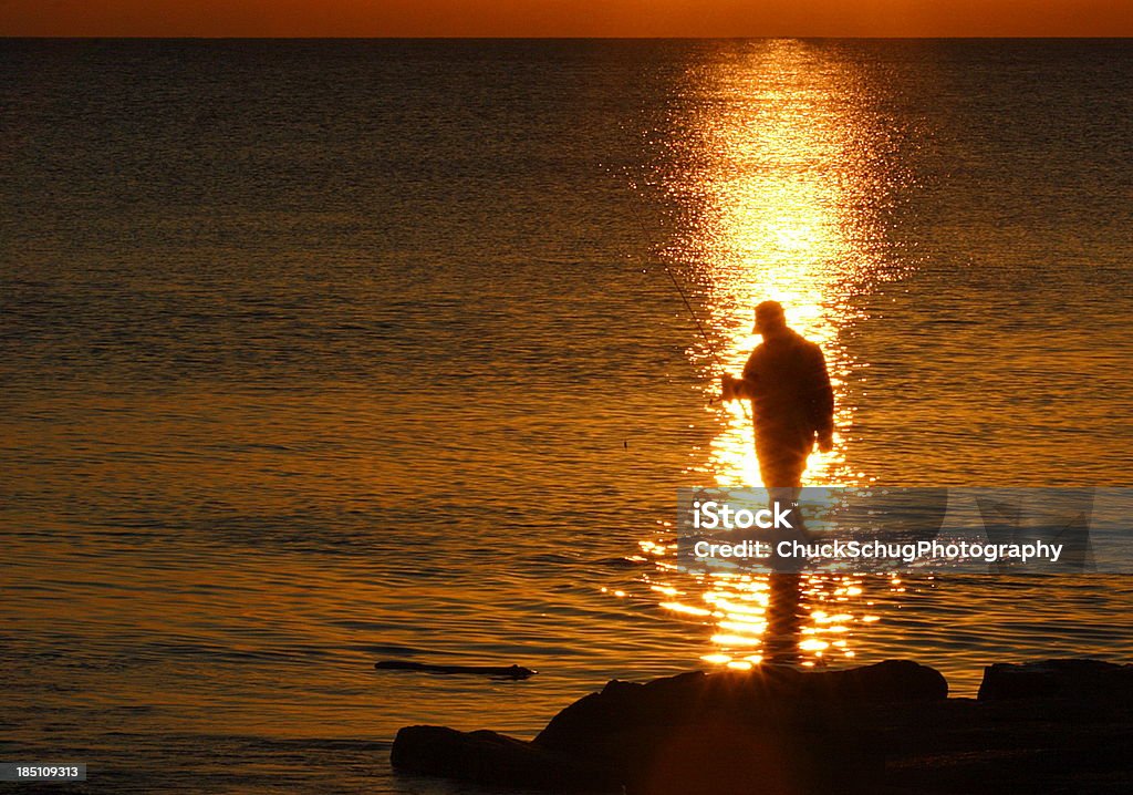 Pescatore Silhouette tramonto Lago - Foto stock royalty-free di Pesca in mare dalla riva