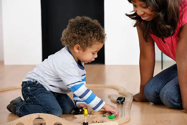 Photo of African American Woman And Toddler Playing With Train