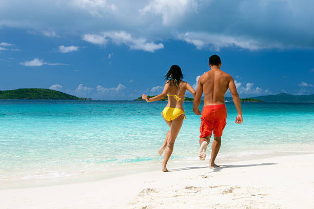 пара, бег на карибском пляже shoreline - swimwear caribbean sea beach water стоковые фото и изображения