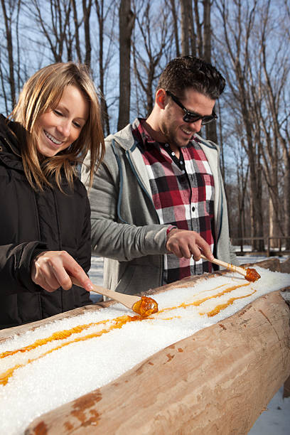 istock couple eat Maple taffy on a sunny day 185110391