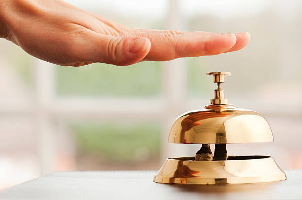 istock Hand ringing service bell on desk beside window 185110712