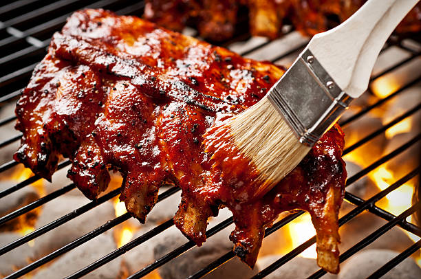 Grilling Ribs Rack of baby back ribs on the grill.  Please see my portfolio for other food related images. barbeque sauce photos stock pictures, royalty-free photos & images