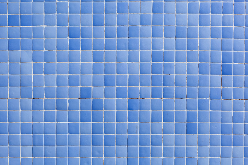 Background from a wall made of square beige mosaic tiles