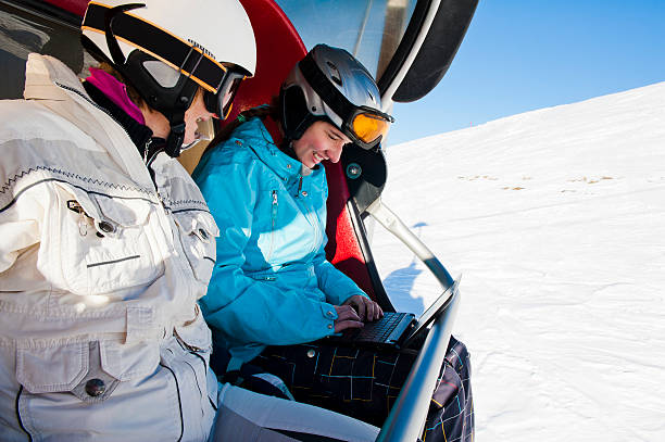 istock Teenage skiers using laptop on ski lift 185111019
