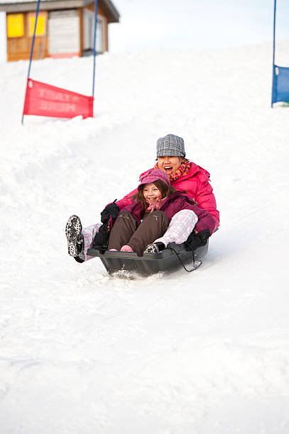 istock Mother and Daughter Sledding 185111850