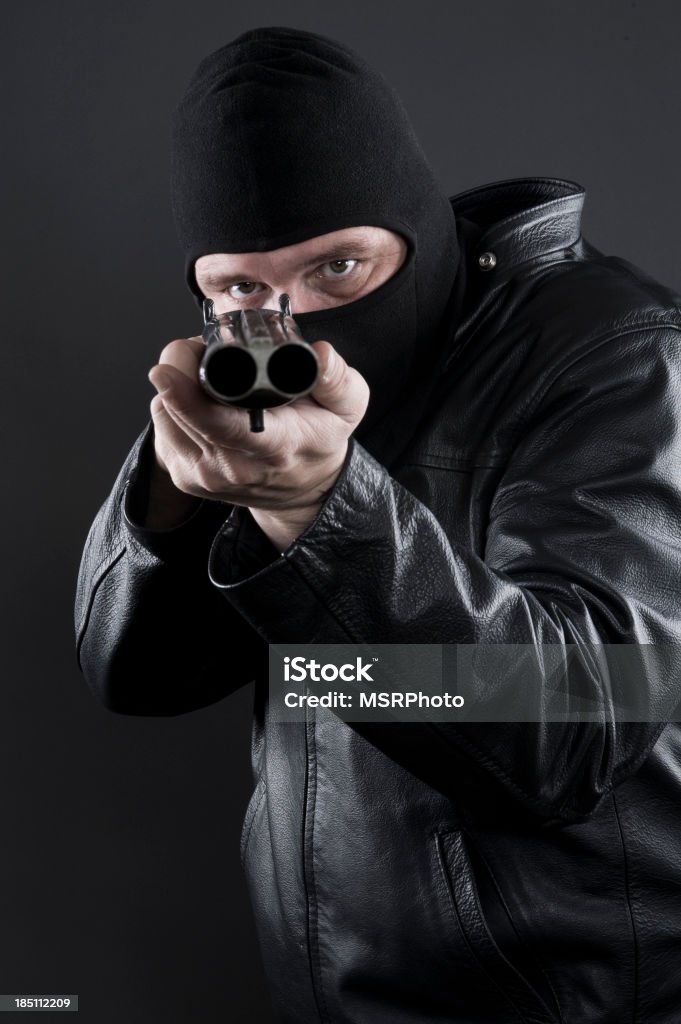 Thug with a Shotgun A man in a balaclava aiming a shotgun at the camera. Bank Robber Stock Photo