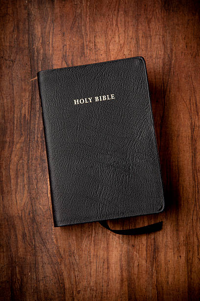 Holy Bible in Black Leather on Wood Background