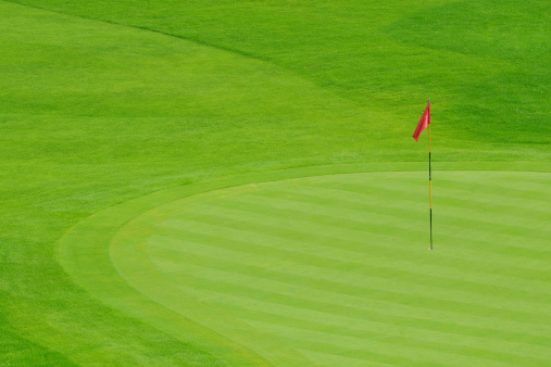 A golf club and a ball during a mini golf game.