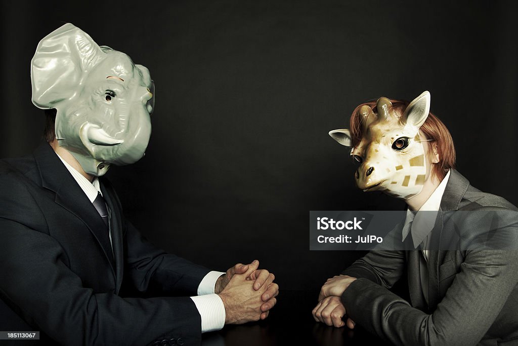 Brainstorming "Businesspeople in animal masks sitting at the table and negotiating, toned image" Elephant Stock Photo