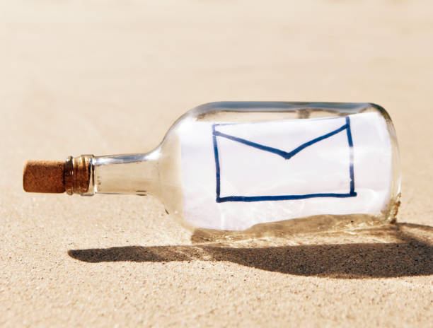 ボトルに続くビーチには、手描きの空白の封筒を開ける - message in a bottle beached bottle desert island ストックフォトと画像