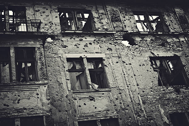 Ruin of War Residental building facade heavily damaged in the Balkans war. Toned image. bosnia and herzegovina stock pictures, royalty-free photos & images
