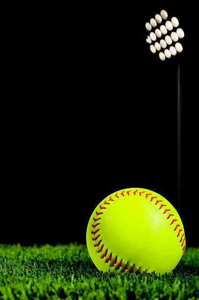 istock Softball in Grass at Night under stadium lights 185114641