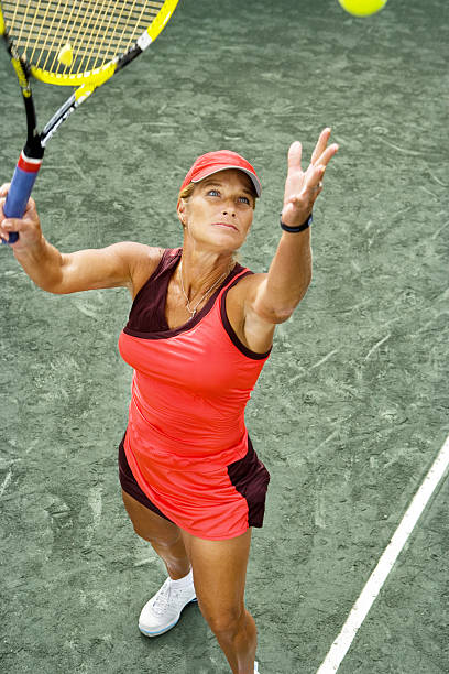 senior mujer jugando al tenis - tennis serving female playing fotografías e imágenes de stock